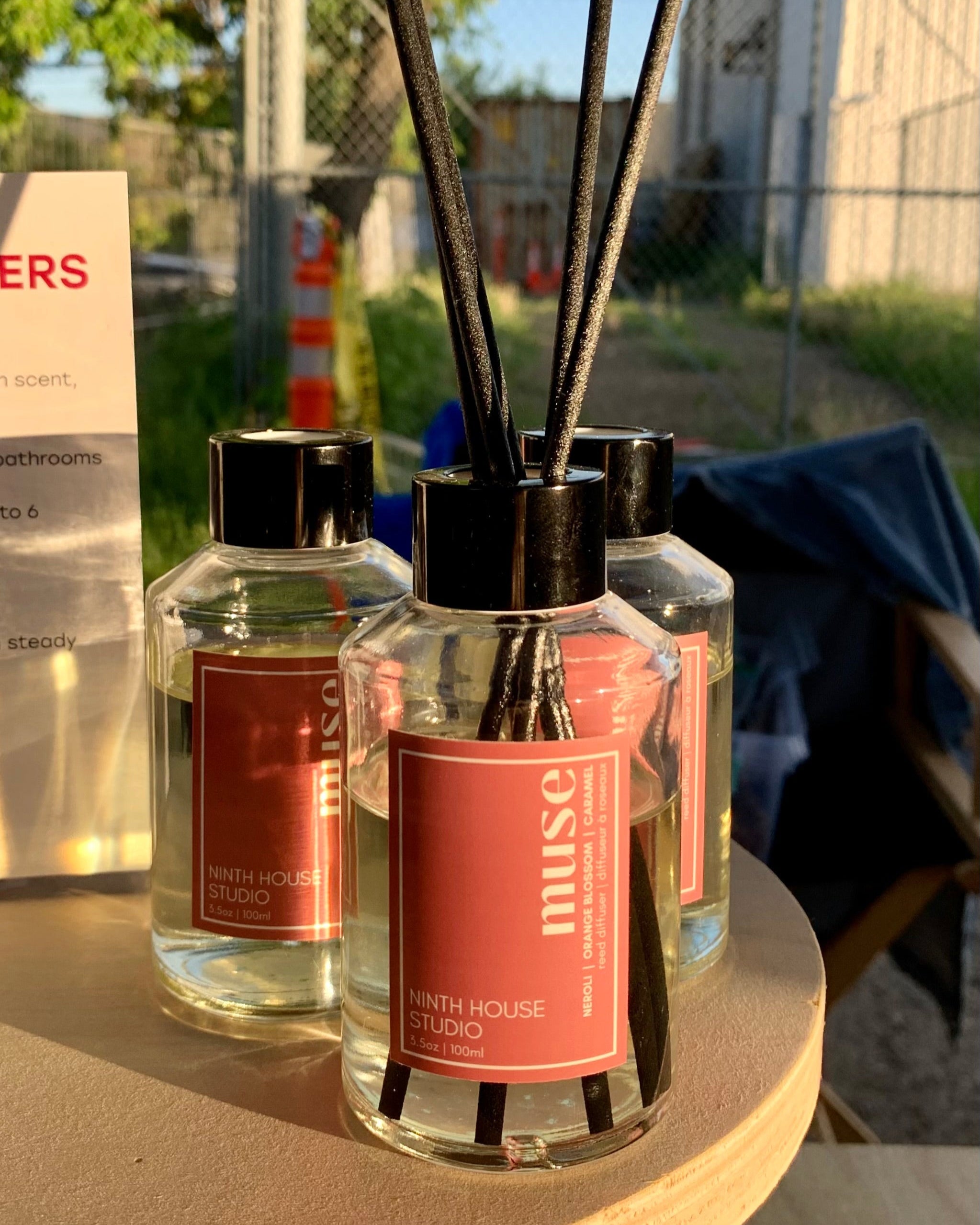 Two diffusers with reeds on a table outdoors