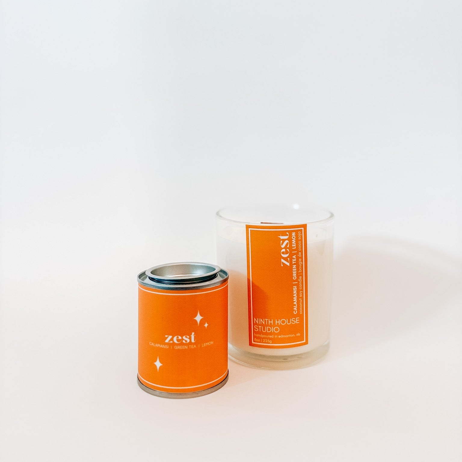 Two candles with 'zest' branding on a white background