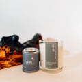 Candle and tin labeled 'Drift' from Ninth House Studio on a light surface with a white background